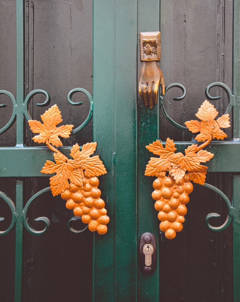 orange fruit wreath hanged on green wooden door